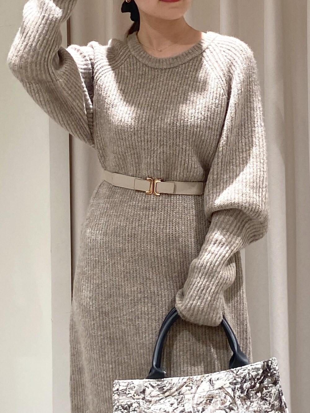 ベージュ系のワンピース、ブラック系のトートバッグ、ブラック系のブーツを着用したレディースの冬コーディネートの2枚目の写真