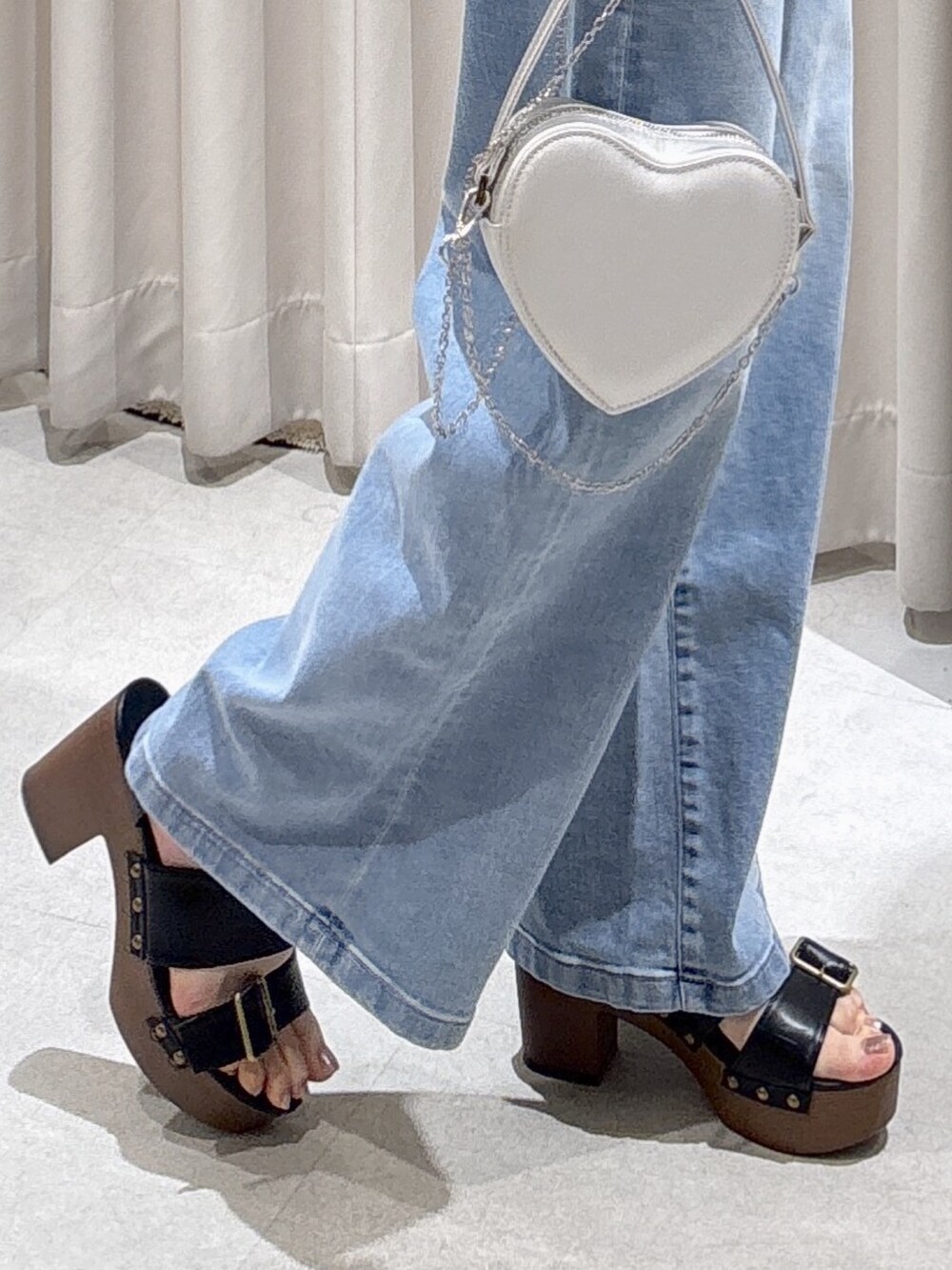 ホワイト系のシャツ/ブラウス、シルバー系のショルダーバッグ、ブルー系のデニムパンツを着用したレディースの春コーディネートの6枚目の写真