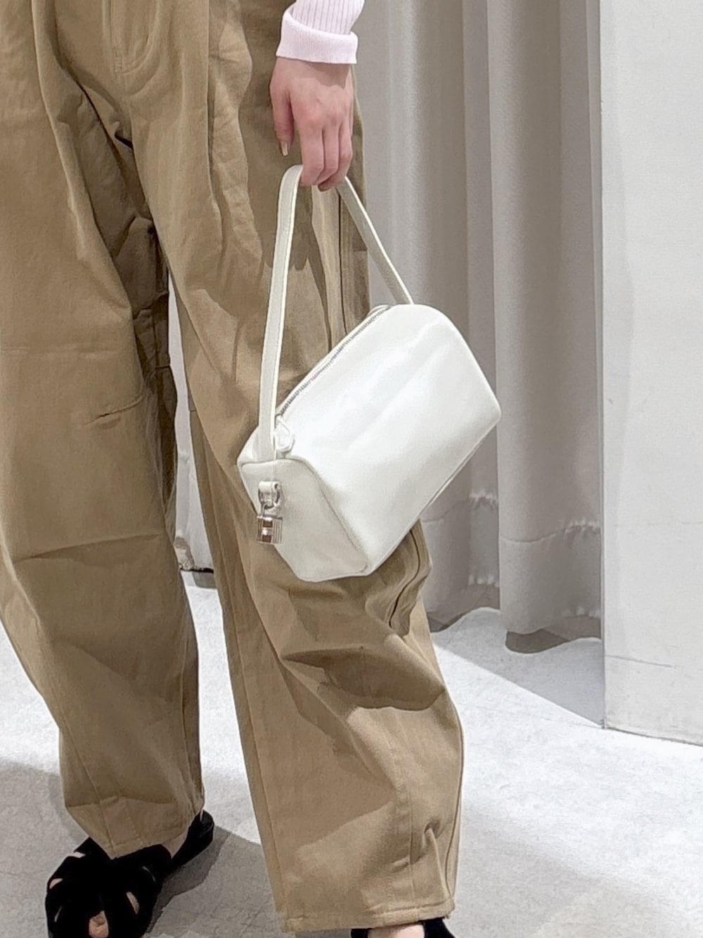 ピンク系のニット/セーター、ベージュ系のその他パンツ、ホワイト系のハンドバッグを着用したレディースの春コーディネートの5枚目の写真