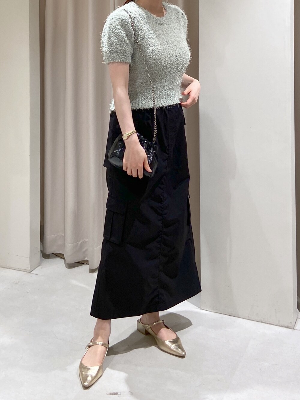 グリーン系のトレンチコート、ブラック系のショルダーバッグ、グリーン系のニット/セーターを着用したレディースの春コーディネートの6枚目の写真