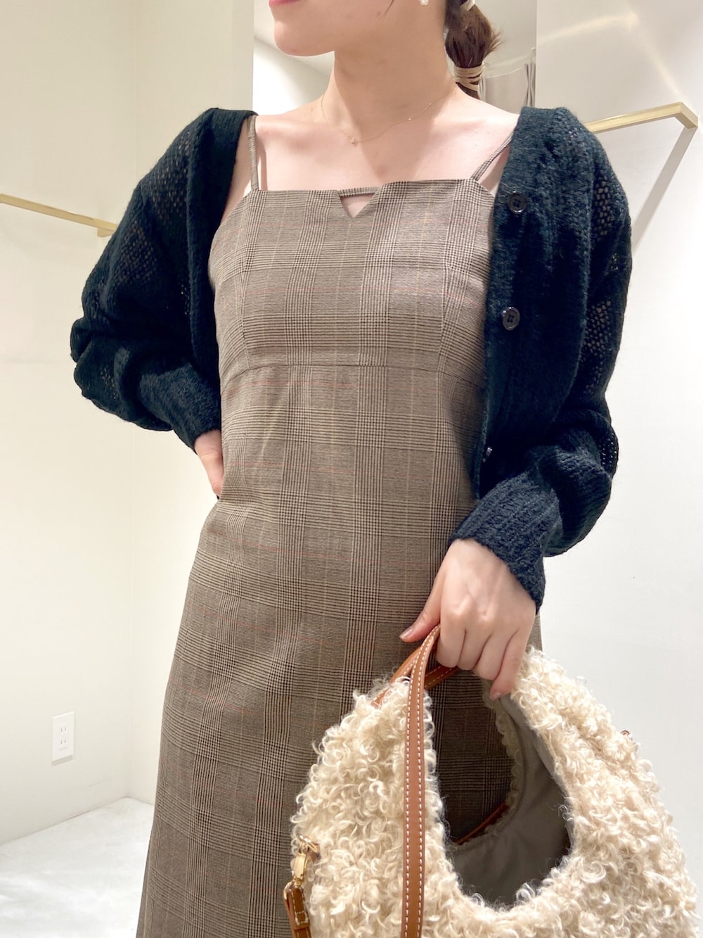ブラウン系のワンピース、ブラック系のカーディガン/ボレロ、ベージュ系のショルダーバッグを着用したレディースの秋コーディネートの4枚目の写真
