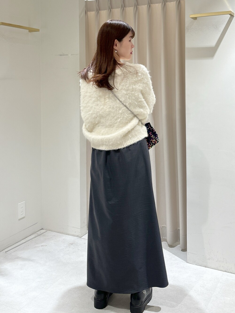 ブラック系のショルダーバッグ、グレー系のスカート、ブラック系のブーツを着用したレディースの冬コーディネートの4枚目の写真