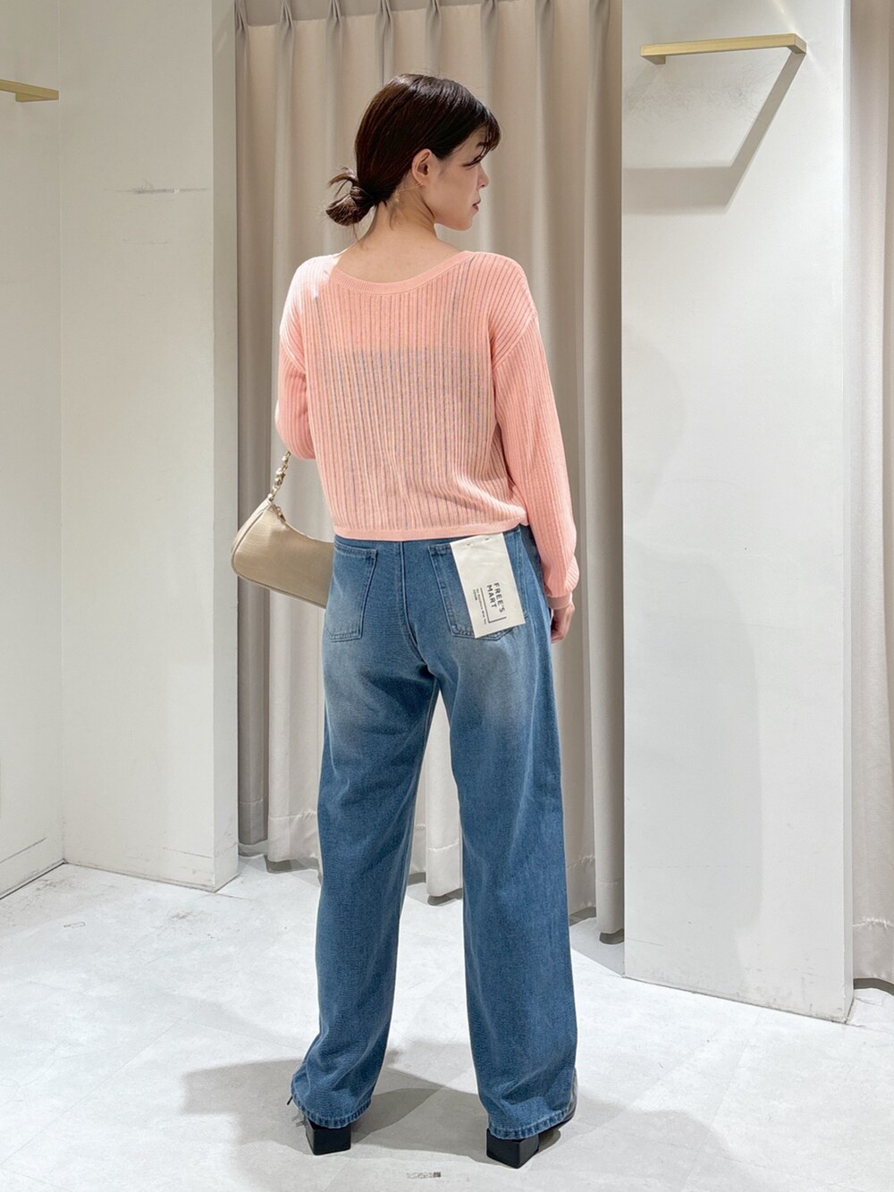 ピンク系のカーディガン/ボレロ、ブラック系のキャミソール、ブルー系のデニムパンツを着用したレディースの秋コーディネートの4枚目の写真