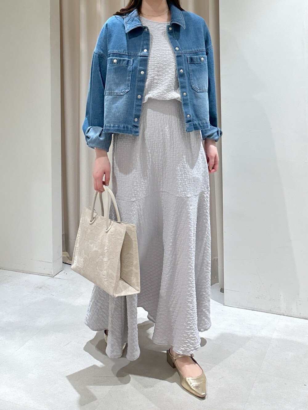 ブルー系のブルゾン、グレー系のワンピース、ホワイト系のトートバッグを着用したレディースの春コーディネートの6枚目の写真