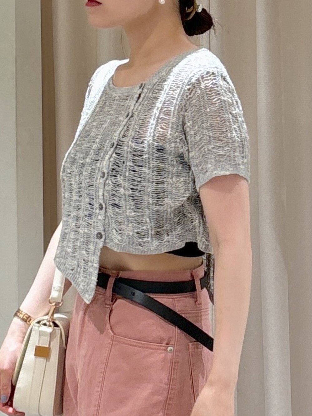 グレー系のニット/セーター、ブラック系のキャミソール、ピンク系のデニムパンツを着用したレディースの夏コーディネートの3枚目の写真