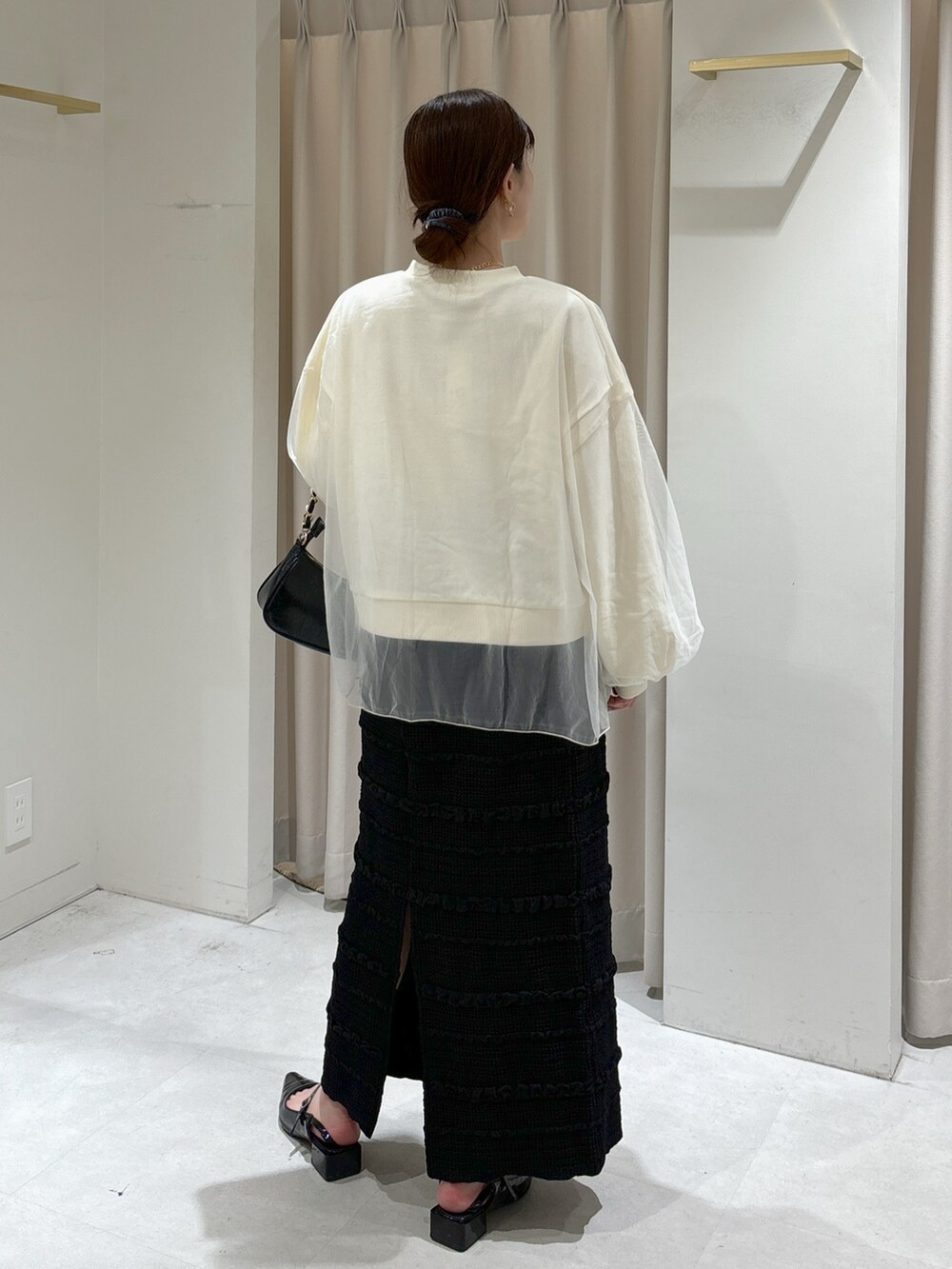 ホワイト系のスウェット、ブラック系のスカート、ブラック系のトートバッグを着用したレディースの秋コーディネートの3枚目の写真