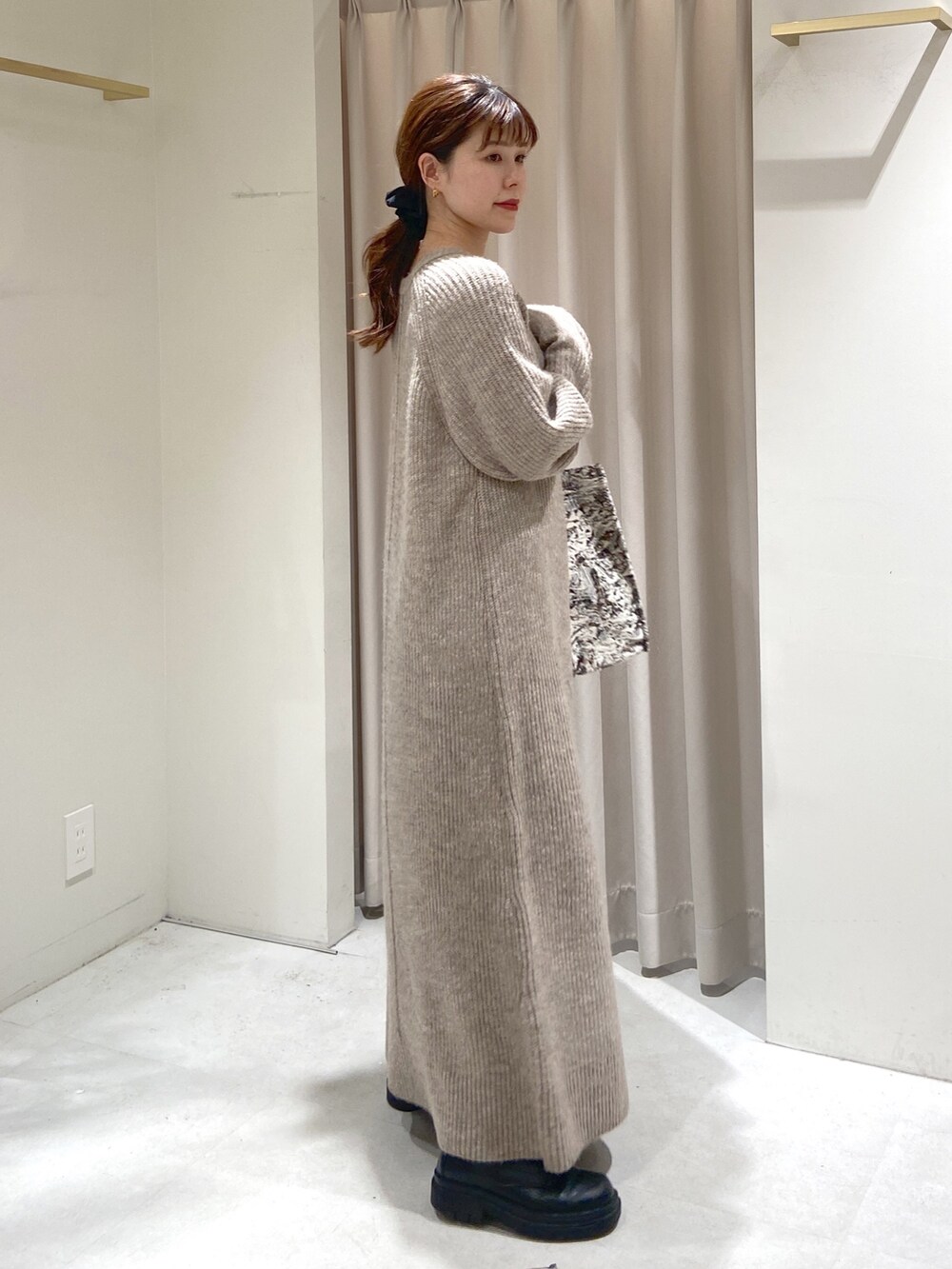 ベージュ系のワンピース、ブラック系のトートバッグ、ブラック系のブーツを着用したレディースの冬コーディネートの3枚目の写真