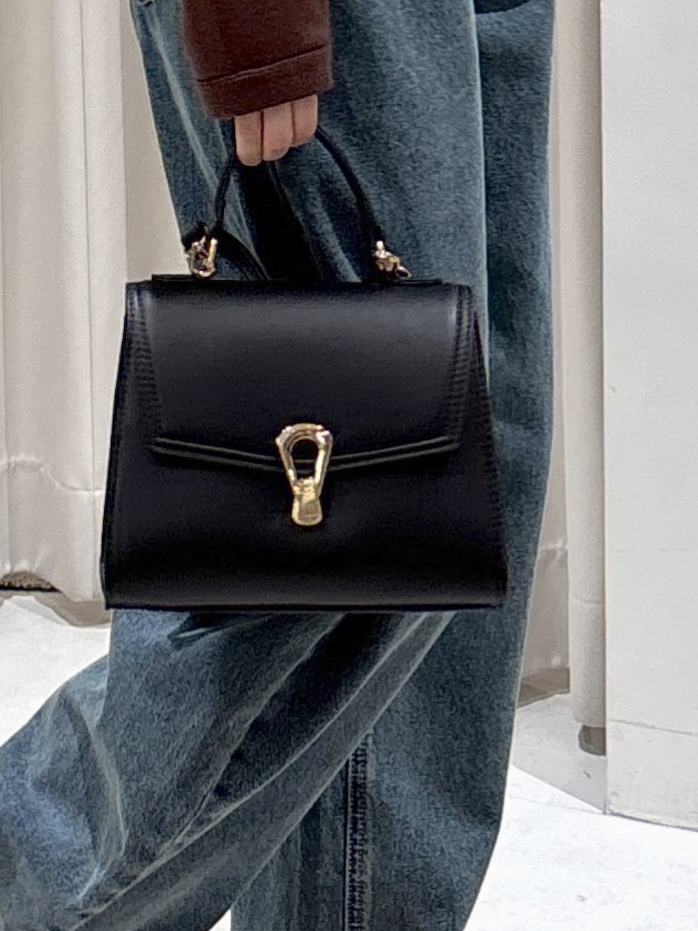 ブラウン系のニット/セーター、ブルー系のデニムパンツ、ブラック系のブーツを着用したレディースの冬コーディネートの4枚目の写真