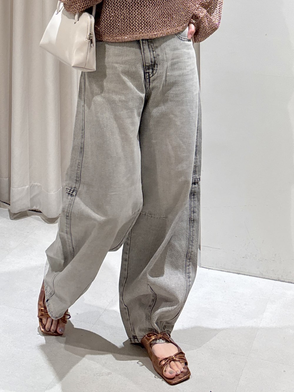 ブラウン系のニット/セーター、ブラック系のキャミソール、グレー系のデニムパンツを着用したレディースの秋コーディネートの4枚目の写真