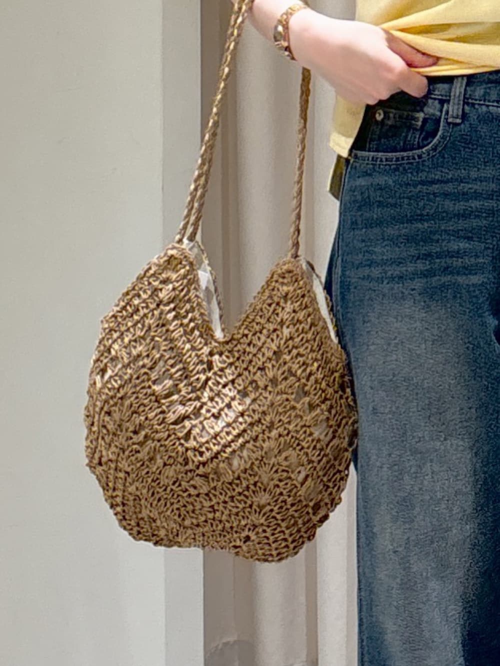 ブラウン系のテーラードジャケット、イエロー系のTシャツ/カットソー、ブルー系のデニムパンツを着用したレディースの春コーディネートの8枚目の写真