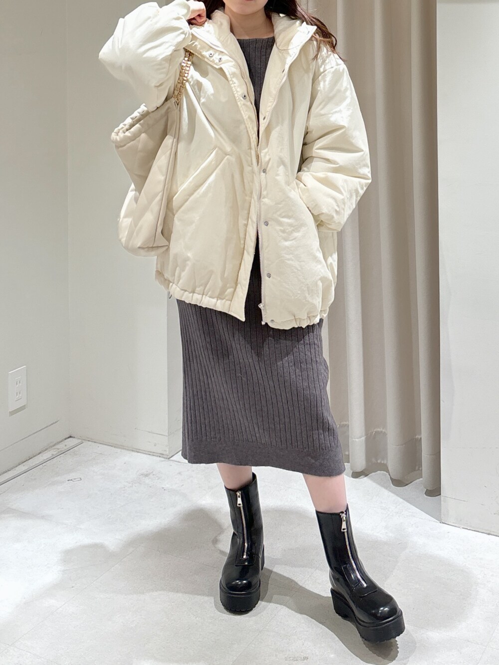 ホワイト系のブルゾン、グレー系のワンピース、ホワイト系のトートバッグを着用したレディースの冬コーディネートの5枚目の写真
