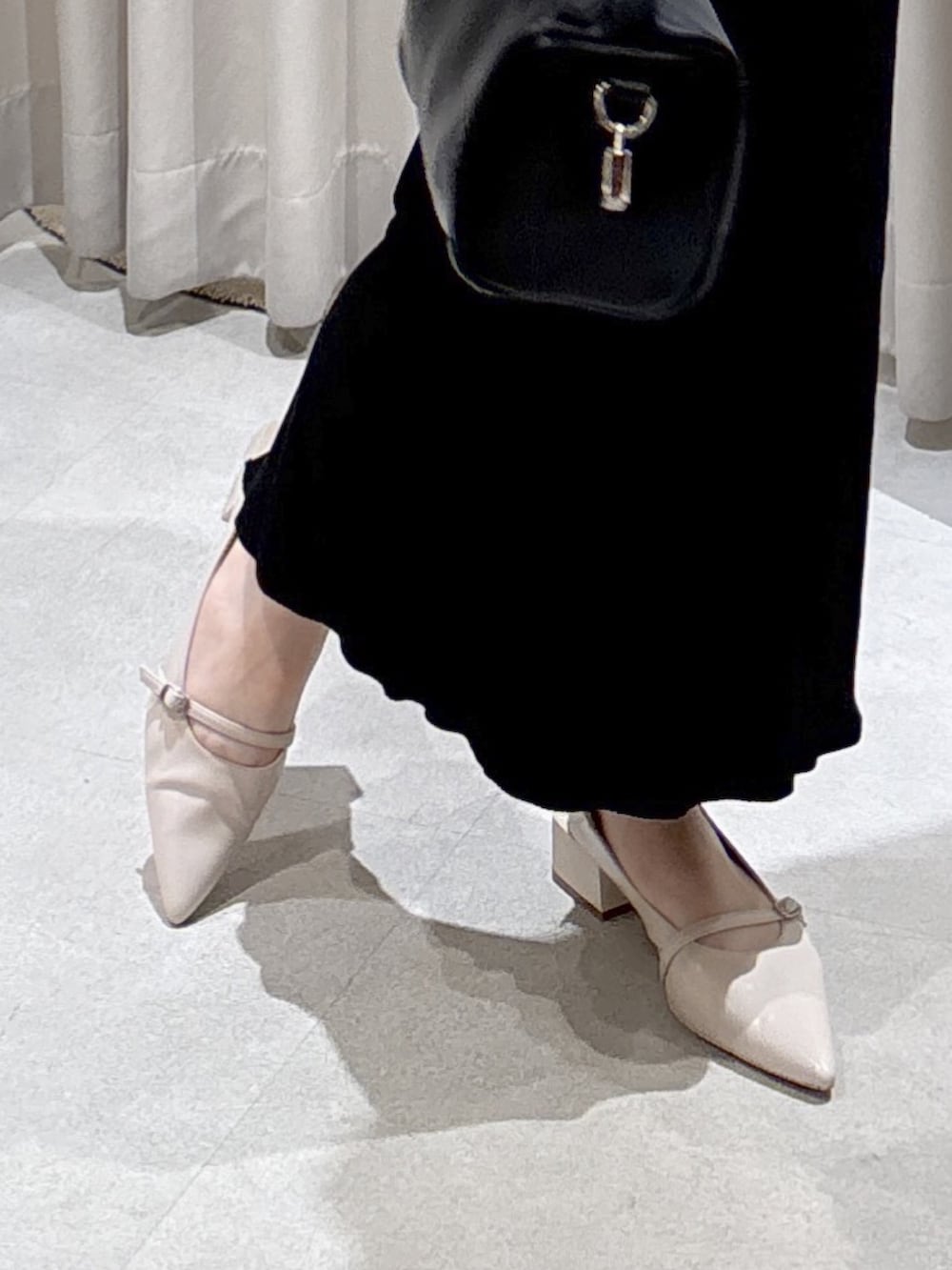 ブルー系のシャツ/ブラウス、ブラック系のハンドバッグ、ブラック系のスカートを着用したレディースの春コーディネートの7枚目の写真