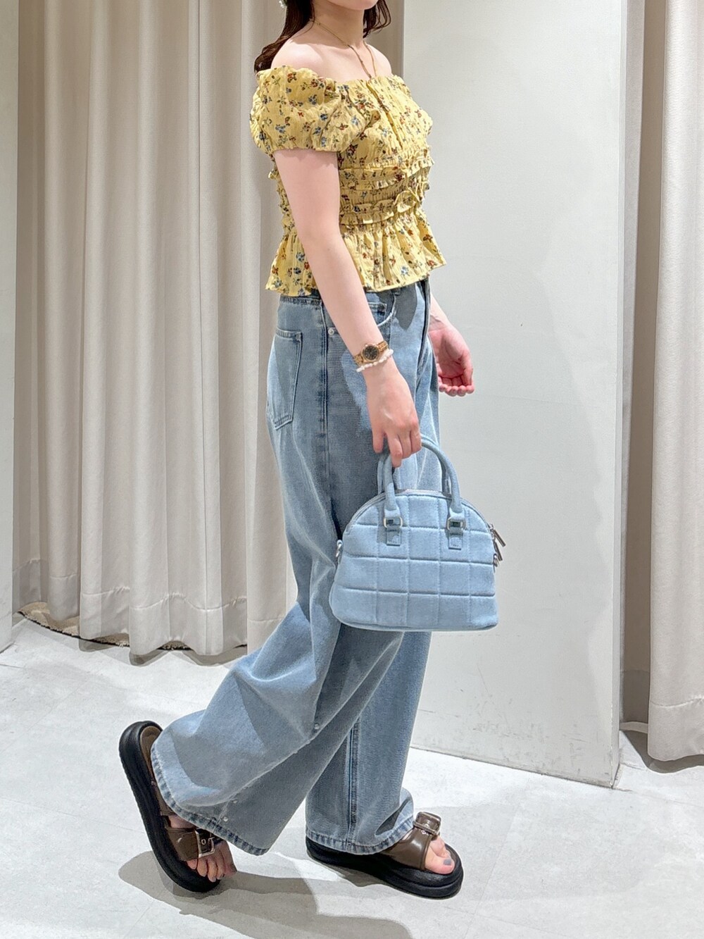 イエロー系のシャツ/ブラウス、ブルー系のトートバッグ、ブルー系のデニムパンツを着用したレディースの夏コーディネートの7枚目の写真