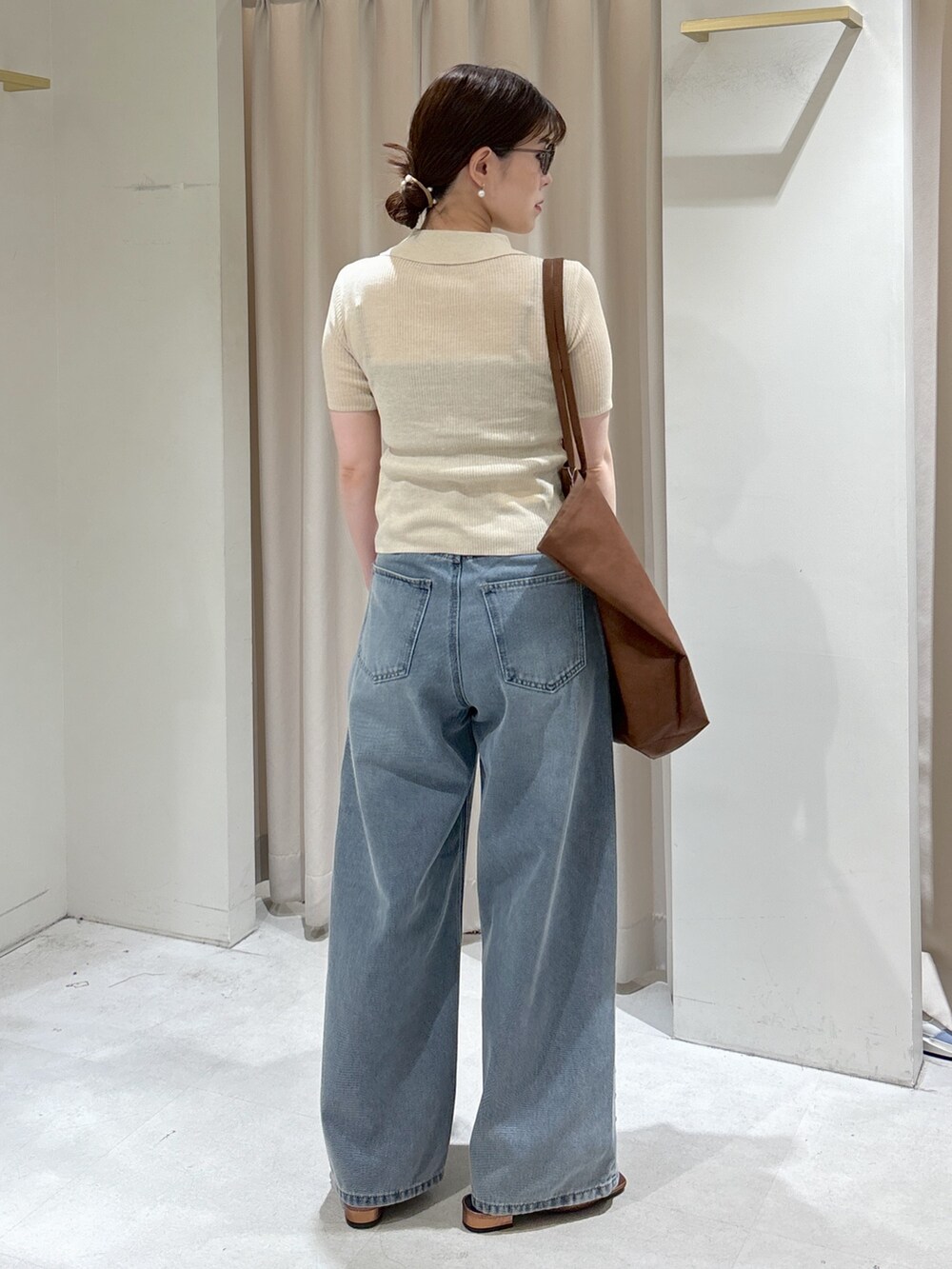 ブルー系のデニムパンツ、ブラウン系のサンダル、ブラック系のキャミソールを着用したレディースの春コーディネートの3枚目の写真