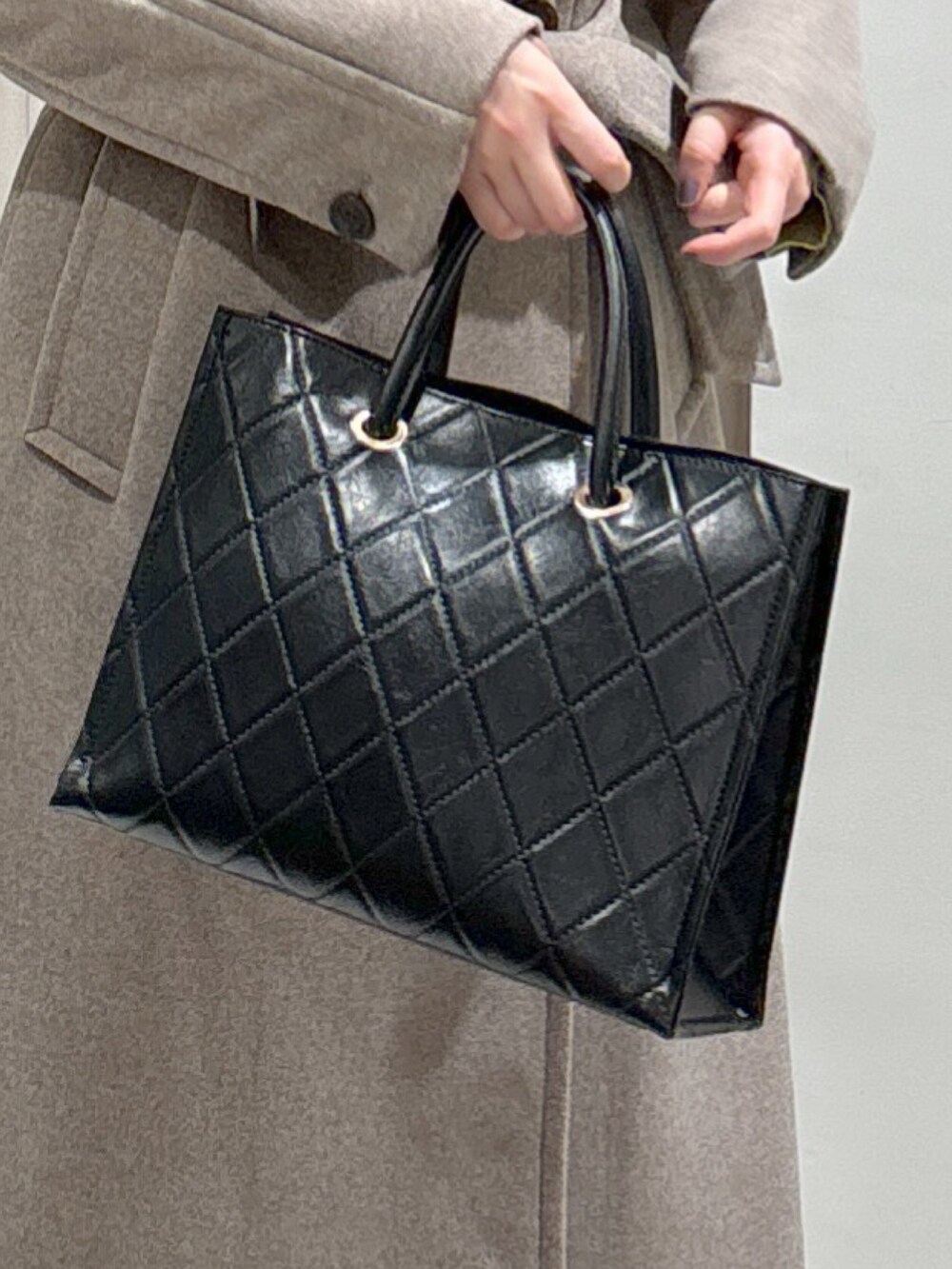 ブラウン系のステンカラーコート、ブラック系のショルダーバッグ、ブラック系のパンプスを着用したレディースの秋コーディネートの6枚目の写真