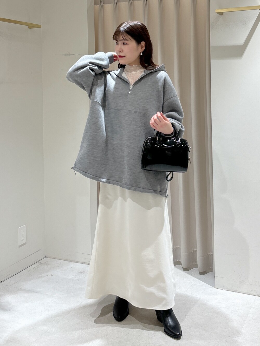 ベージュ系のブルゾン、ブラック系のショルダーバッグ、ホワイト系のスカートを着用したレディースの冬コーディネートの8枚目の写真