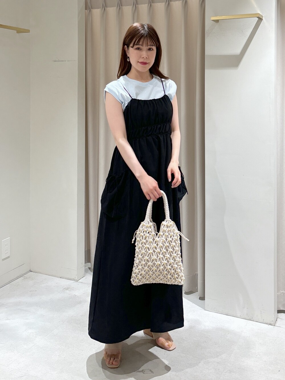 ブラック系のワンピース、グレー系のサンダル、ホワイト系のハンドバッグを着用したレディースの春コーディネートの2枚目の写真