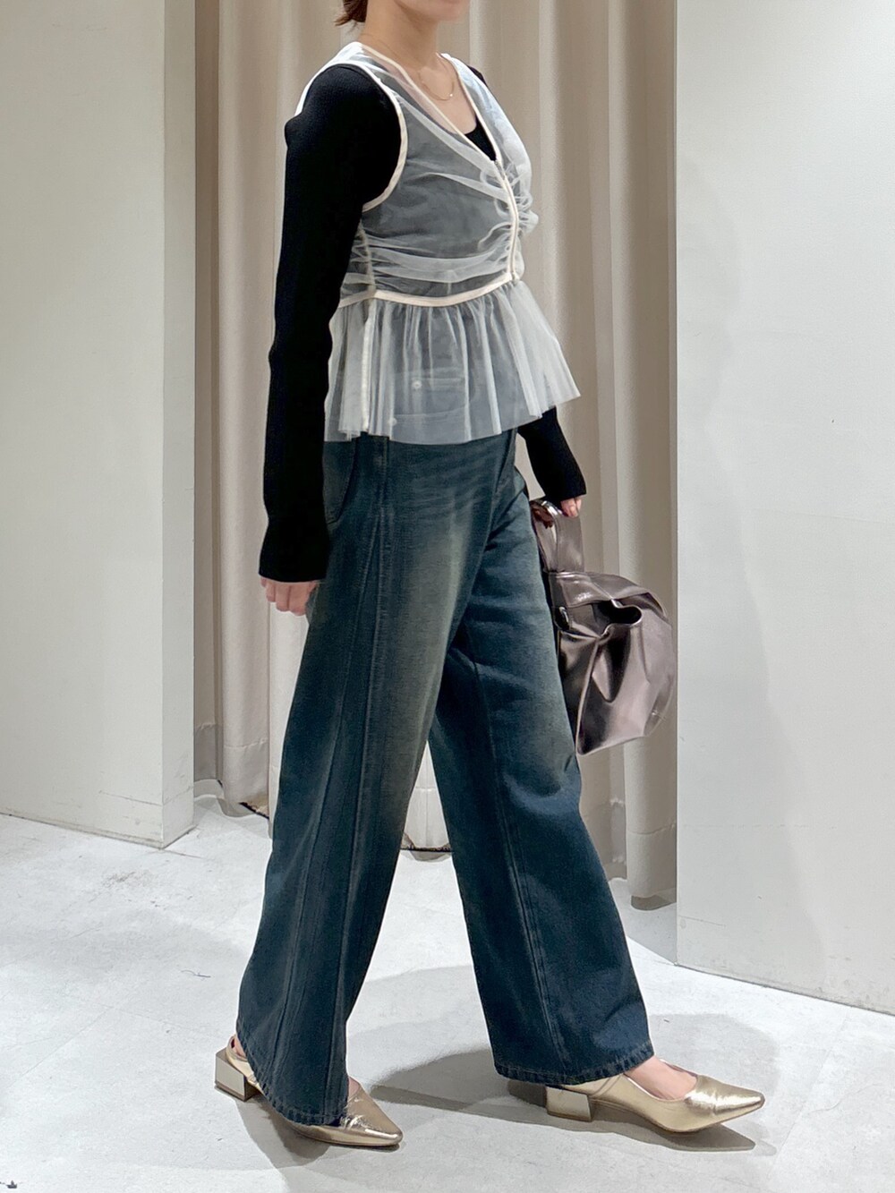 ホワイト系のシャツ/ブラウス、ブラック系のニット/セーター、シルバー系のハンドバッグを着用したレディースの秋コーディネートの2枚目の写真