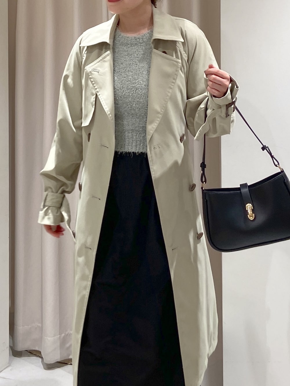 グリーン系のトレンチコート、ブラック系のショルダーバッグ、グリーン系のニット/セーターを着用したレディースの春コーディネートの5枚目の写真