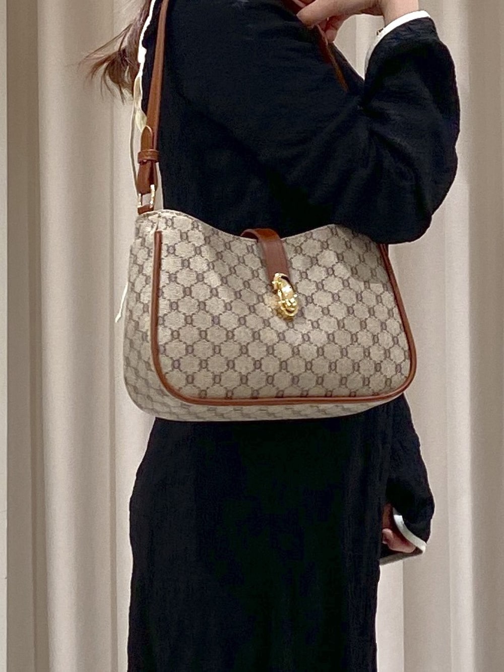 ブラック系のワンピース、ベージュ系のショルダーバッグ、ゴールド系のパンプスを着用したレディースの春コーディネートの4枚目の写真