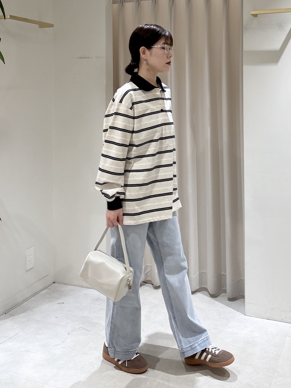 グレー系のTシャツ/カットソー、ホワイト系のハンドバッグ、ブルー系のデニムパンツを着用したレディースの春コーディネートの6枚目の写真