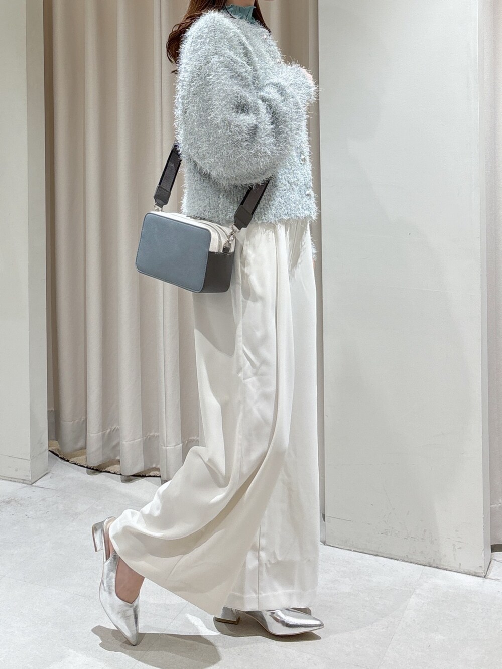 グリーン系のカーディガン/ボレロ、グリーン系のTシャツ/カットソー、ホワイト系のスラックスを着用したレディースの冬コーディネートの7枚目の写真