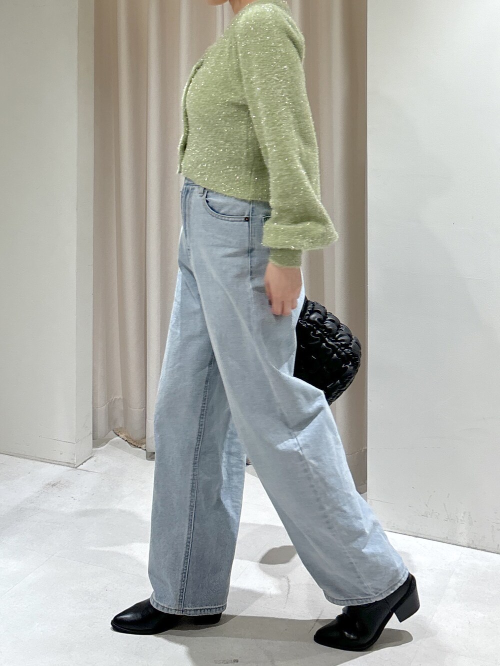 グリーン系のカーディガン/ボレロ、ブルー系のデニムパンツ、ブラック系のハンドバッグを着用したレディースの秋コーディネートの5枚目の写真