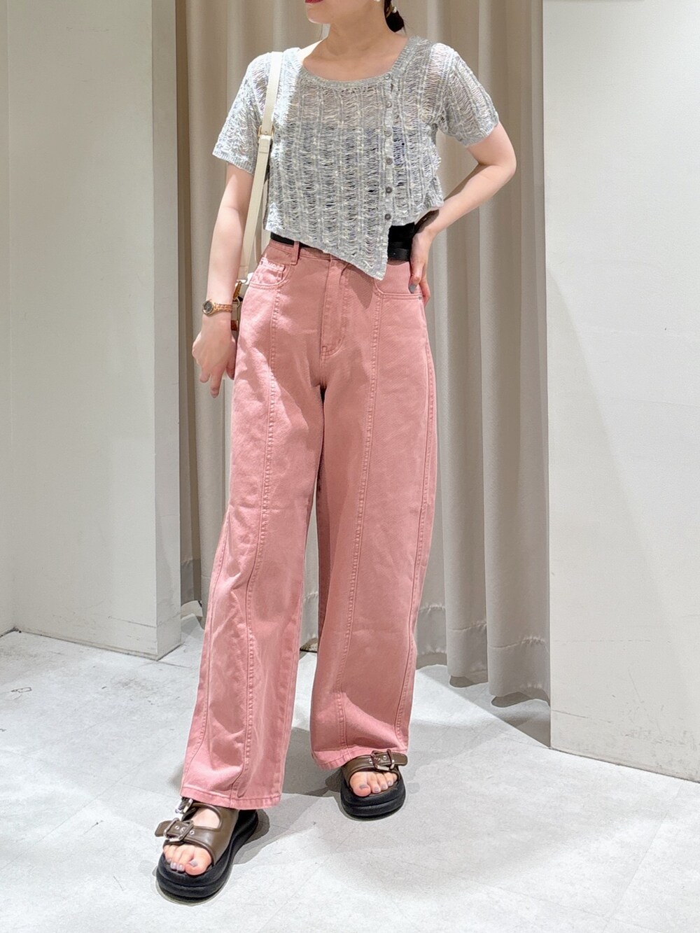 グレー系のニット/セーター、ブラック系のキャミソール、ピンク系のデニムパンツを着用したレディースの夏コーディネートの2枚目の写真