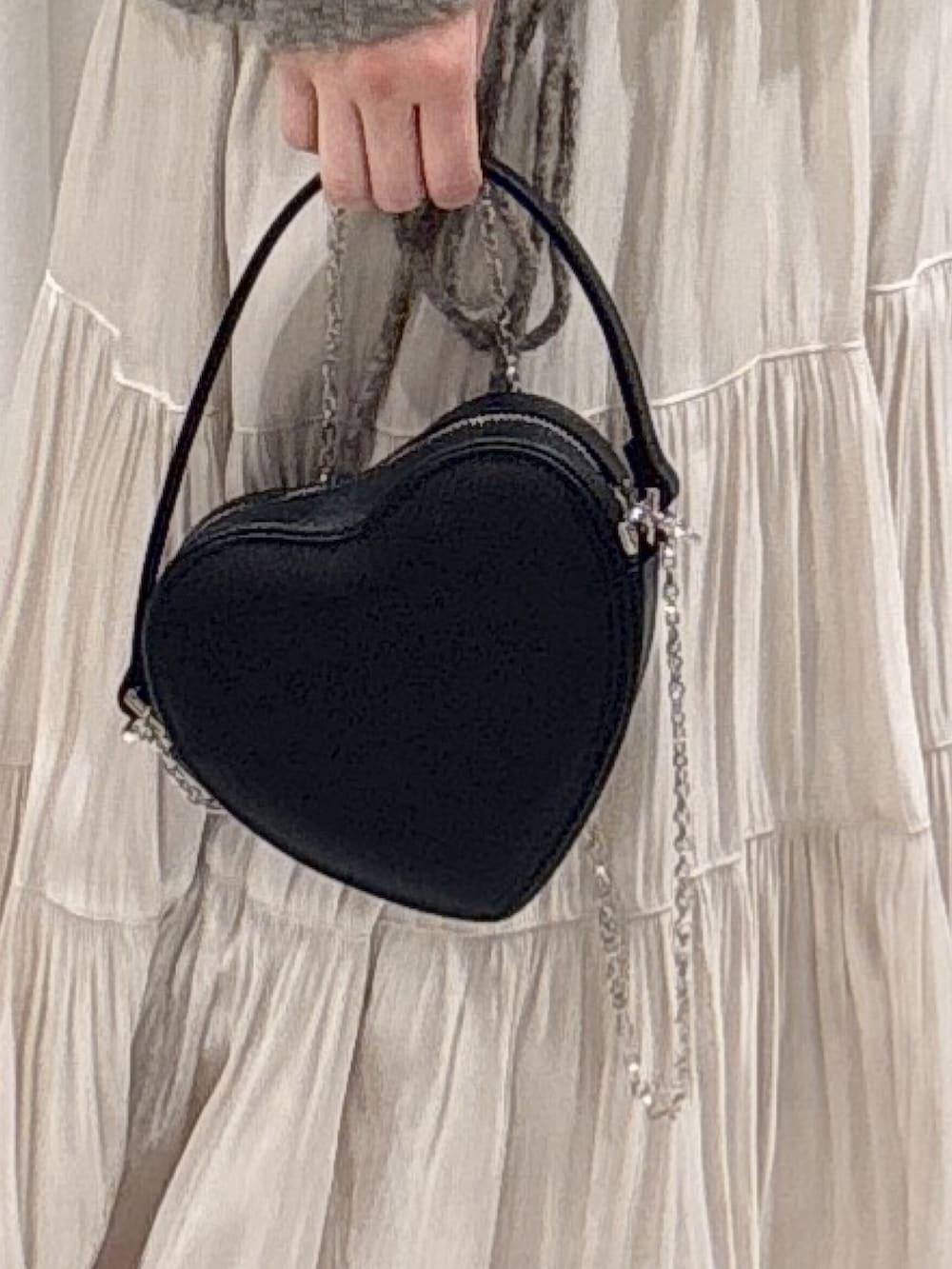 ブラウン系のニット/セーター、ホワイト系のスカート、ブラウン系のパンプスを着用したレディースの冬コーディネートの7枚目の写真