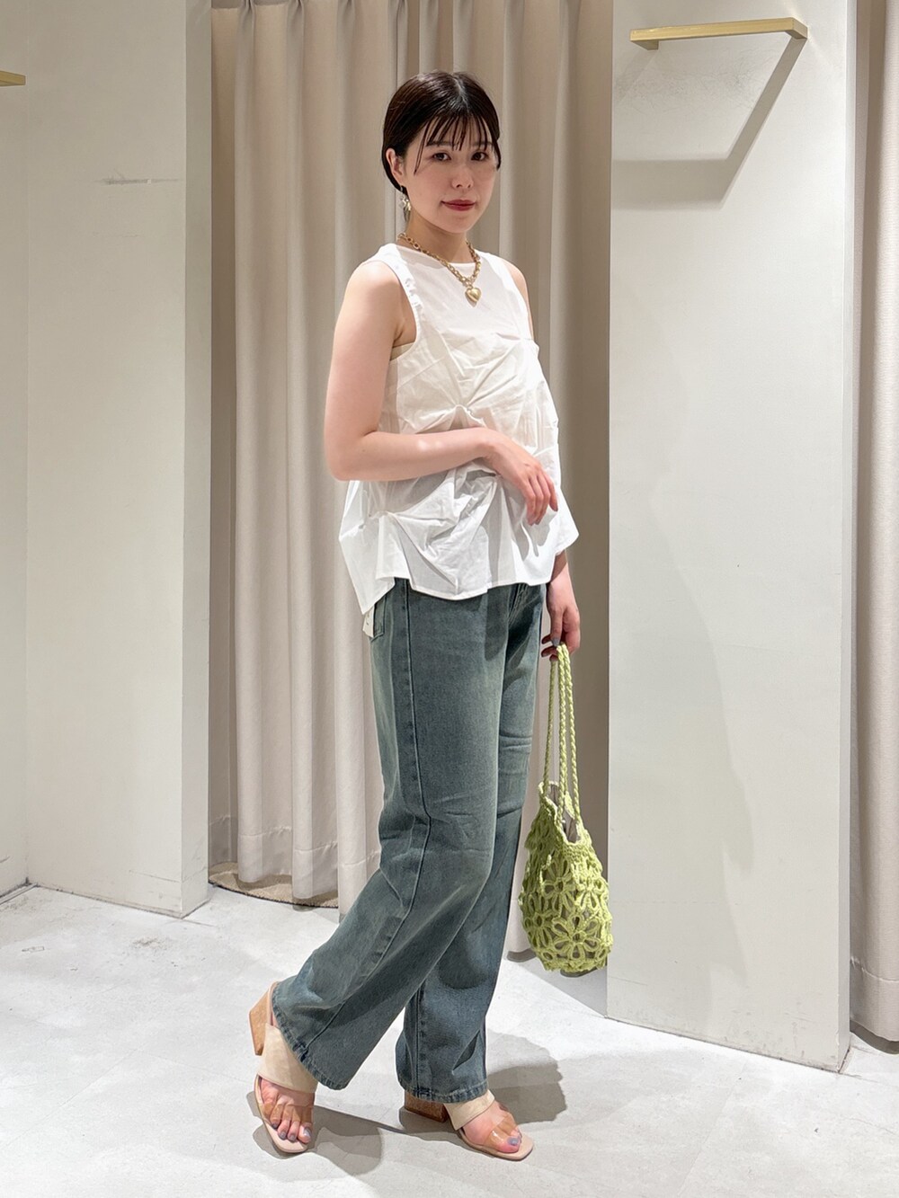 ホワイト系のシャツ/ブラウス、ブルー系のデニムパンツ、グレー系のサンダルを着用したレディースの夏コーディネートの6枚目の写真