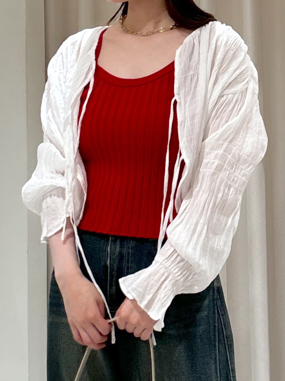 レッド系のタンクトップ、ブルー系のデニムパンツ、グレー系のショルダーバッグを着用したレディースの夏コーディネートの6枚目の写真