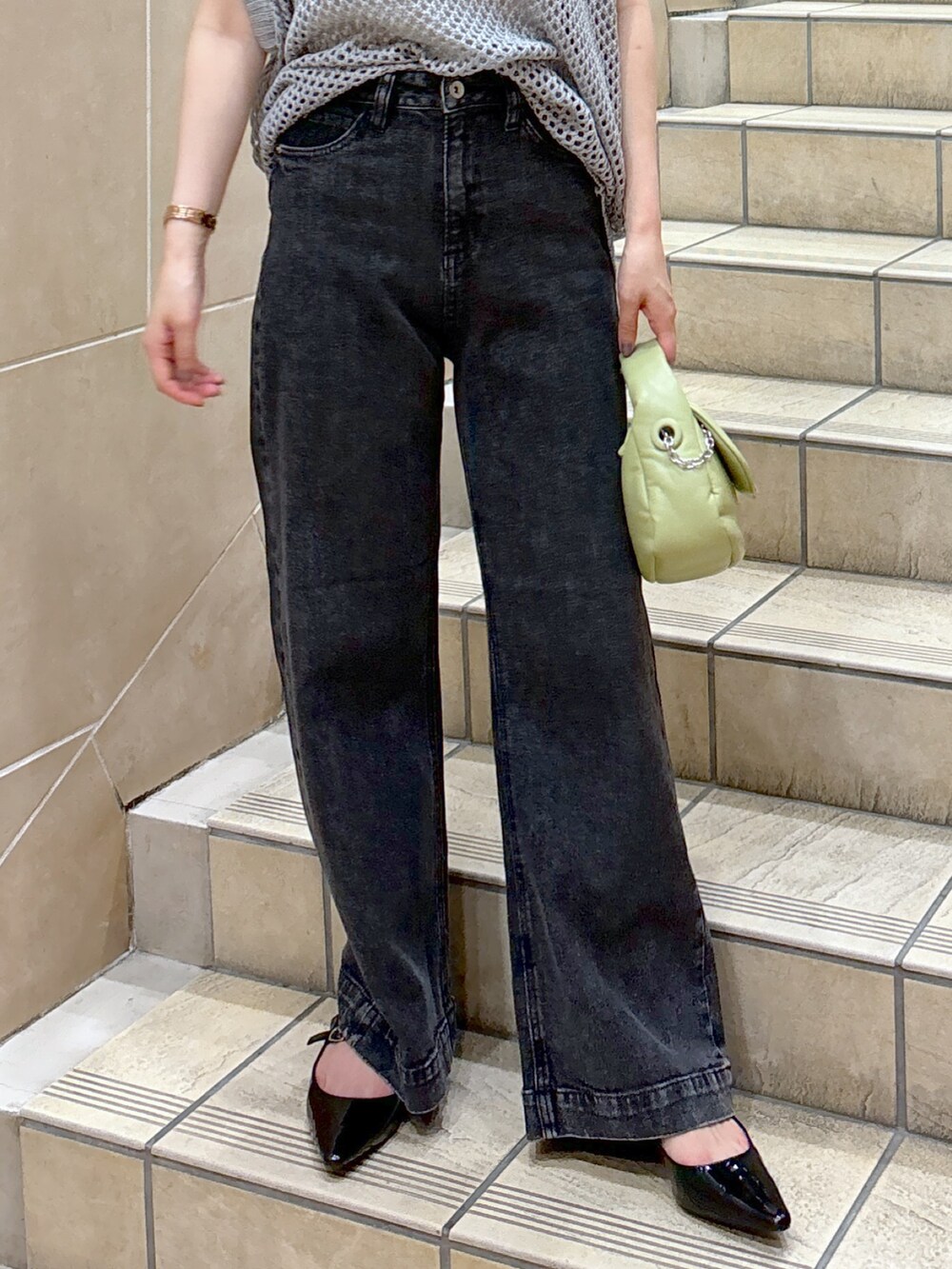 グレー系のニット/セーター、ホワイト系のキャミソール、グリーン系のショルダーバッグを着用したレディースの夏コーディネートの4枚目の写真