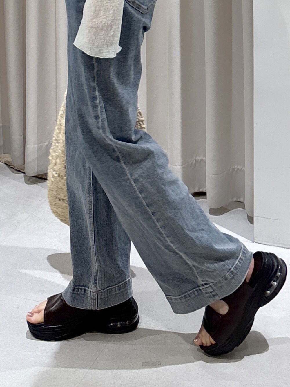 グリーン系のTシャツ/カットソー、ホワイト系のキャミソール、ブルー系のデニムパンツを着用したレディースの夏コーディネートの4枚目の写真