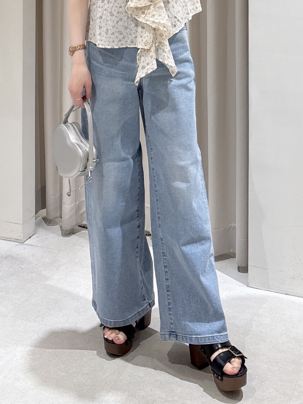 ホワイト系のシャツ/ブラウス、シルバー系のショルダーバッグ、ブルー系のデニムパンツを着用したレディースの春コーディネートの5枚目の写真