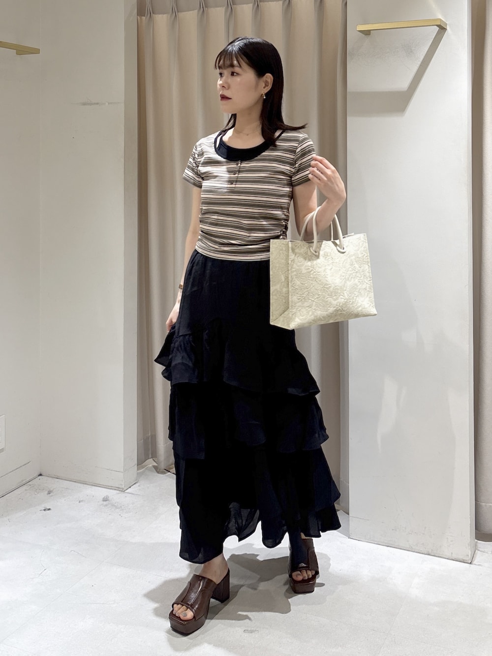 ブラウン系のTシャツ/カットソー、ホワイト系のトートバッグ、ブラック系のスカートを着用したレディースの夏コーディネートの5枚目の写真