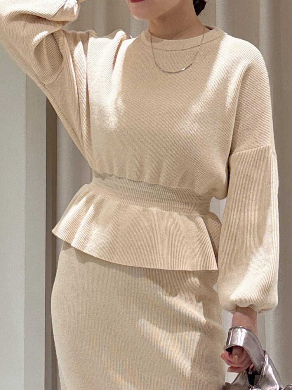 ホワイト系のワンピース、シルバー系のハンドバッグ、ブラック系のブーツを着用したレディースの秋コーディネートの2枚目の写真