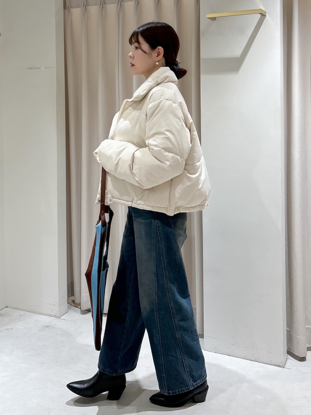 ホワイト系のブルゾン、グリーン系のニット/セーター、ブラウン系のショルダーバッグを着用したレディースの冬コーディネートの4枚目の写真