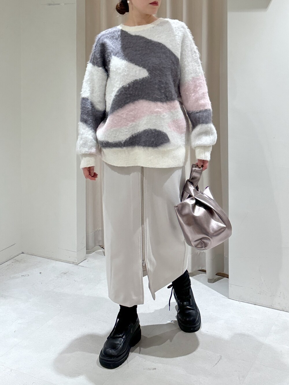 ホワイト系のニット/セーター、グレー系のスカート、シルバー系のハンドバッグを着用したレディースの冬コーディネートの5枚目の写真