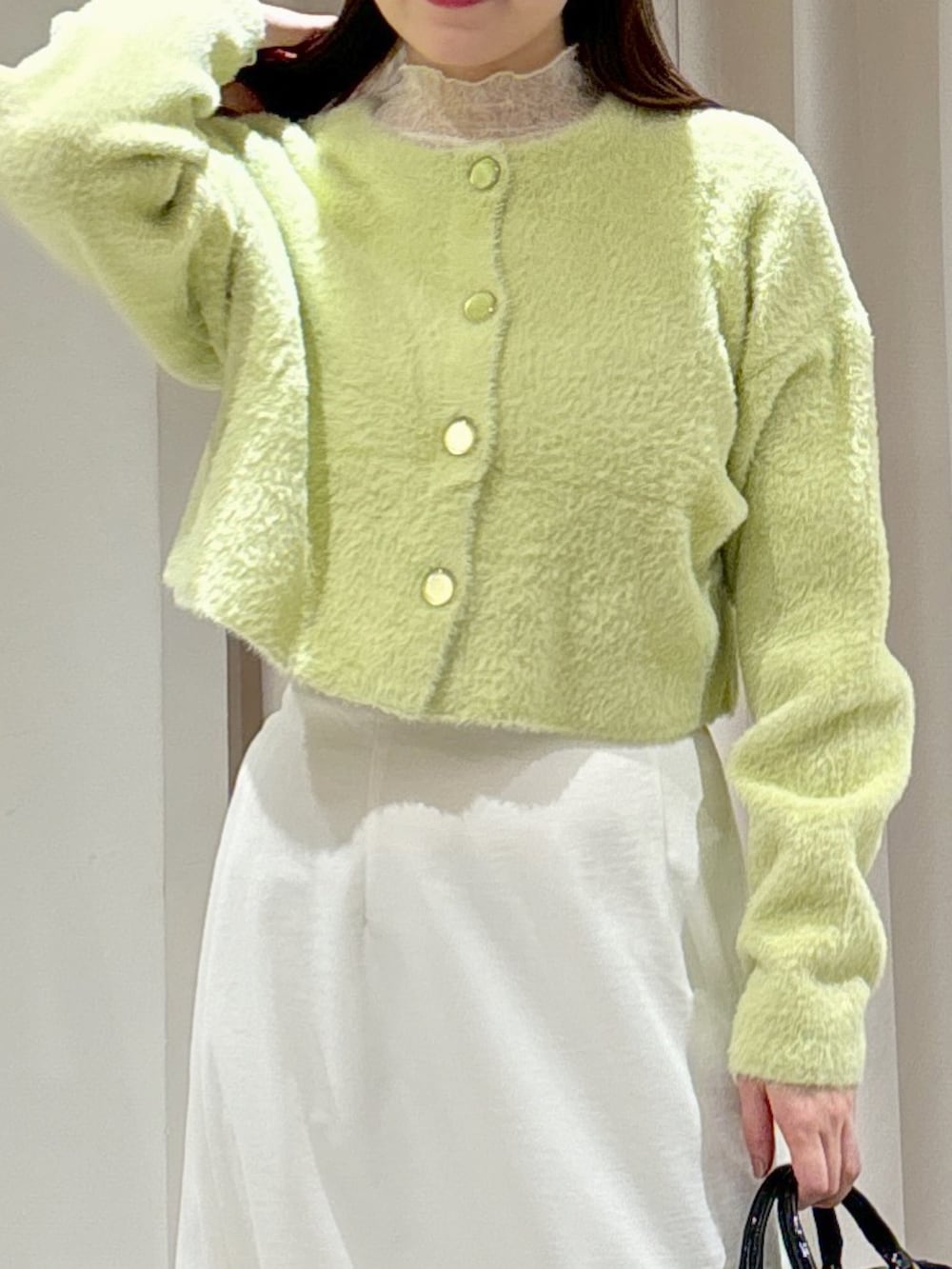 グリーン系のカーディガン/ボレロ、ホワイト系のTシャツ/カットソー、ホワイト系のスカートを着用したレディースの冬コーディネートの5枚目の写真