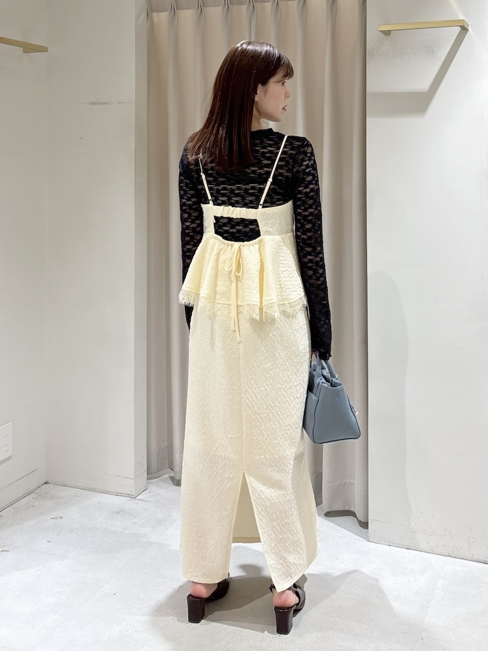 ホワイト系のワンピース、ブラック系のTシャツ/カットソー、ブルー系のハンドバッグを着用したレディースの冬コーディネートの3枚目の写真