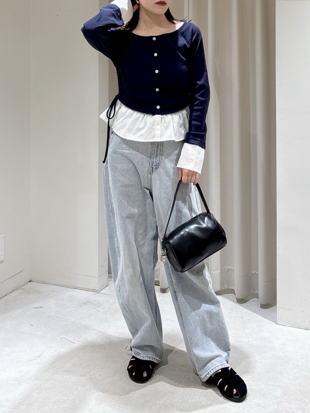 ブルー系のTシャツ/カットソー、ブラック系のハンドバッグ、ブルー系のデニムパンツを着用したレディースの春コーディネートの5枚目の写真