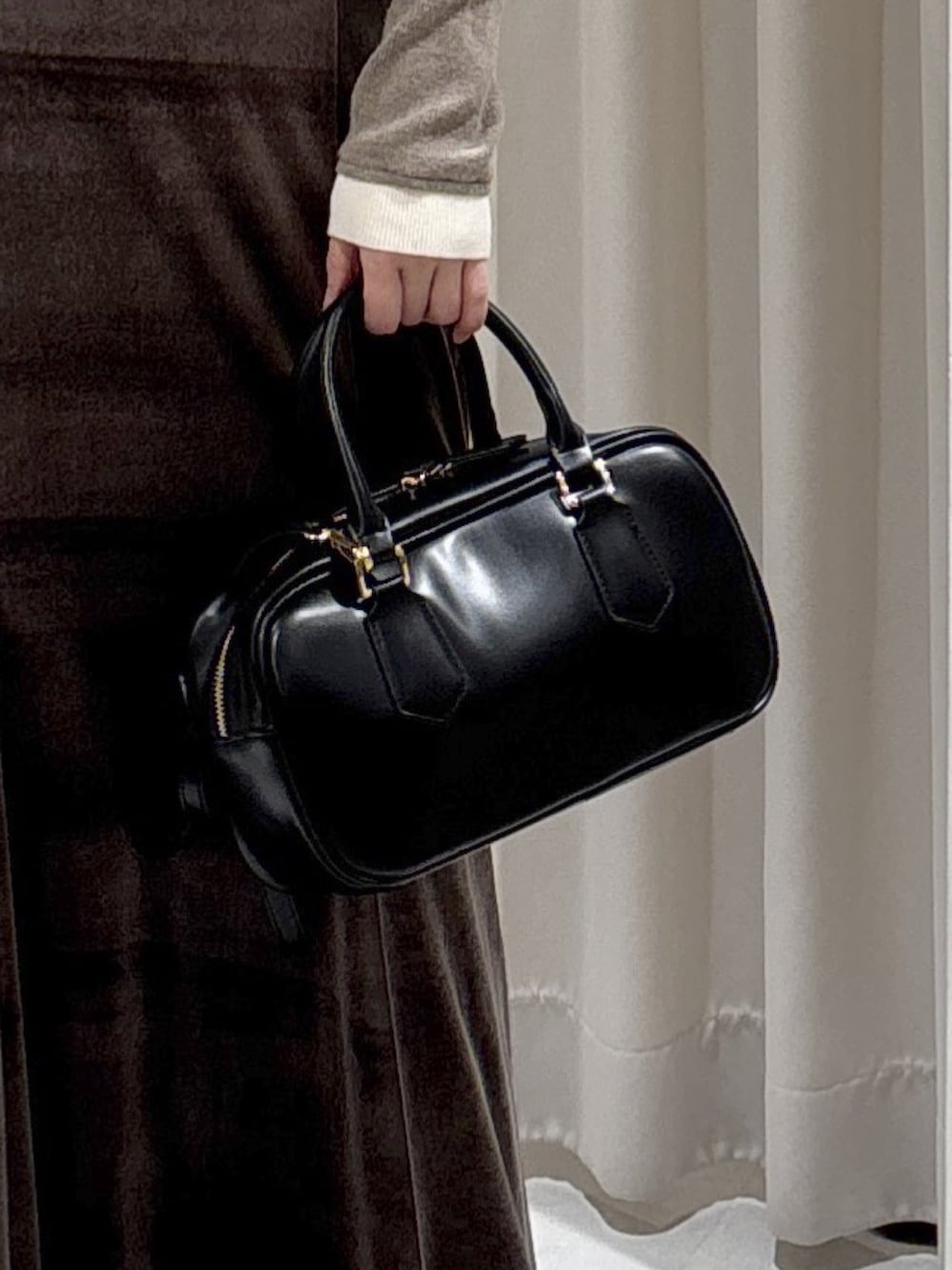 ブラウン系のニット/セーター、ブラウン系のスカート、ブラック系のブーツを着用したレディースの冬コーディネートの3枚目の写真