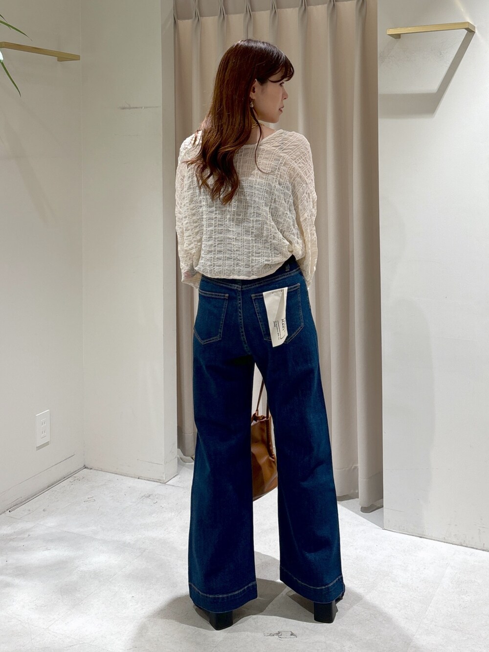 ホワイト系のカーディガン/ボレロ、ブラック系のキャミソール、ブルー系のデニムパンツを着用したレディースの夏コーディネートの5枚目の写真