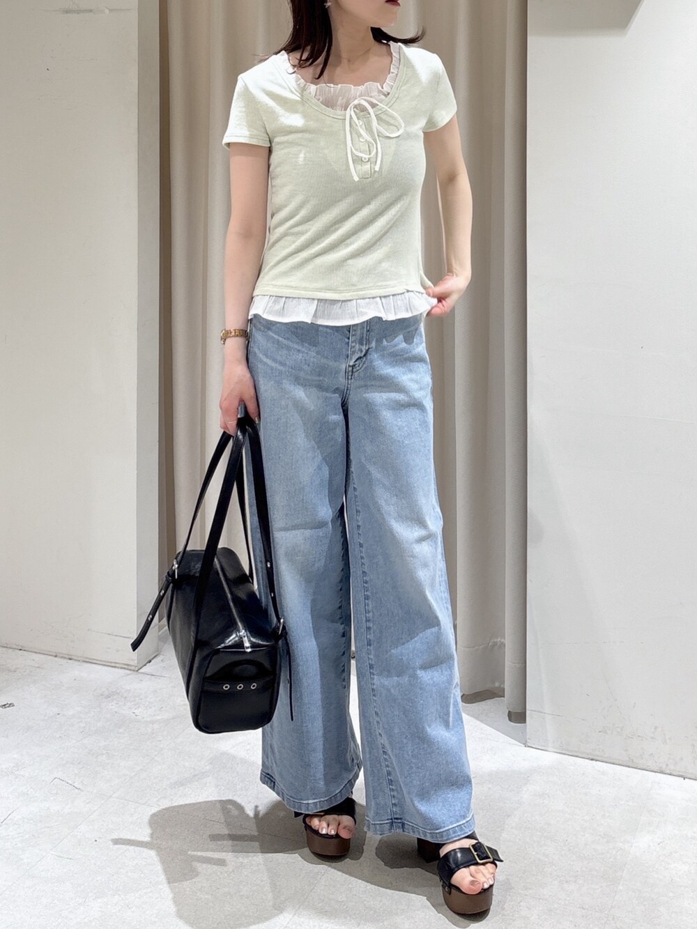 ベージュ系のテーラードジャケット、グリーン系のTシャツ/カットソー、ブルー系のデニムパンツを着用したレディースの春コーディネートの4枚目の写真