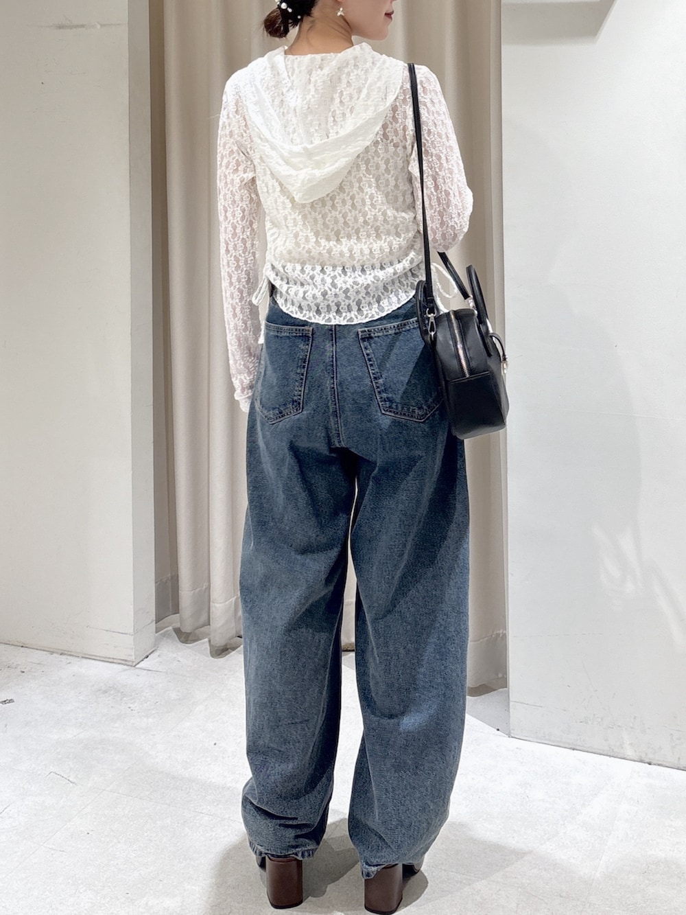 ホワイト系のTシャツ/カットソー、ブラック系のハンドバッグ、ブルー系のデニムパンツを着用したレディースの春コーディネートの6枚目の写真