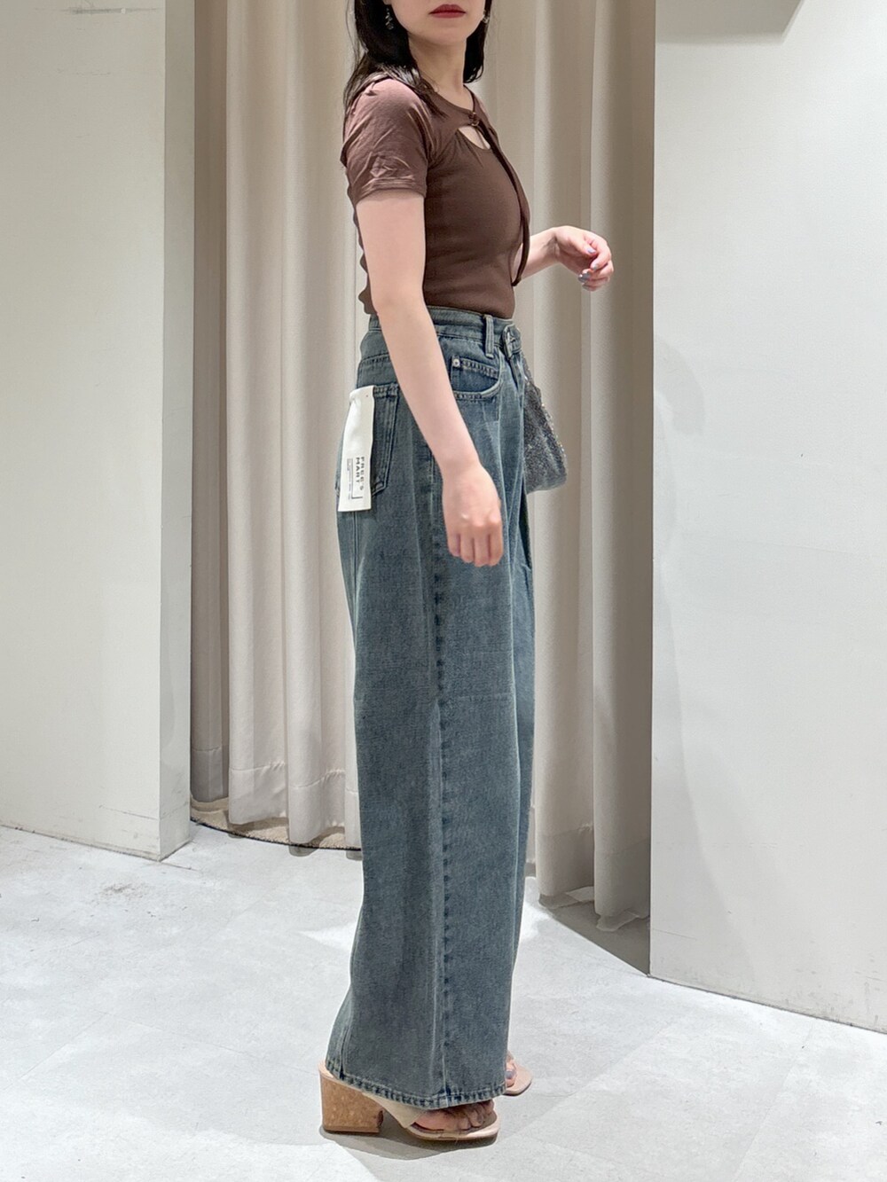 ブラウン系のTシャツ/カットソー、ブルー系のデニムパンツ、シルバー系のハンドバッグを着用したレディースの夏コーディネートの3枚目の写真