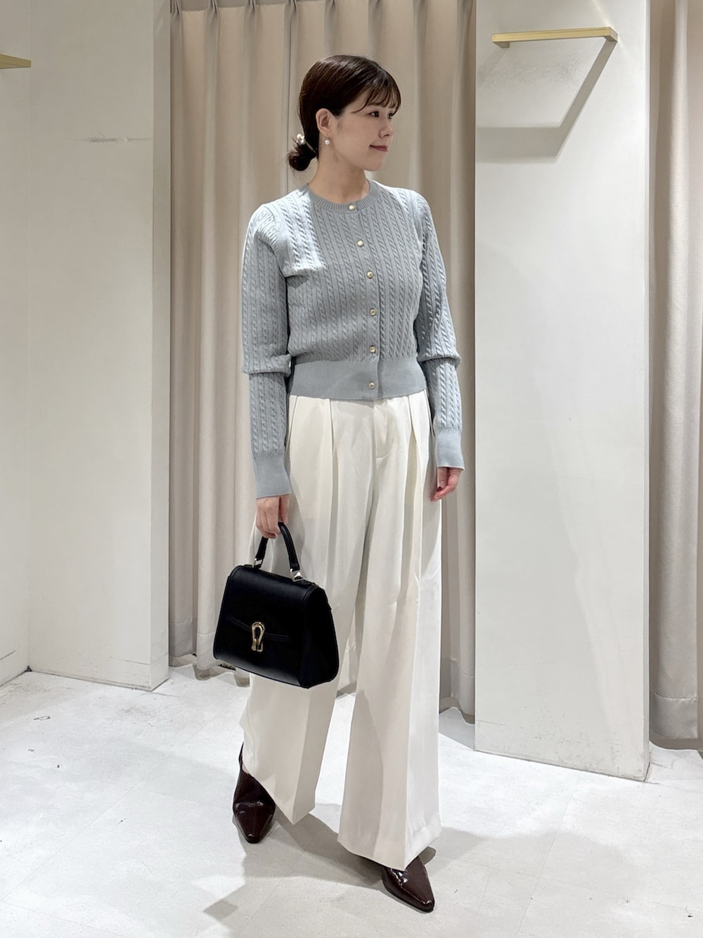 ブルー系のカーディガン/ボレロ、ホワイト系のその他パンツ、ブラック系のトートバッグを着用したレディースの秋コーディネートの2枚目の写真