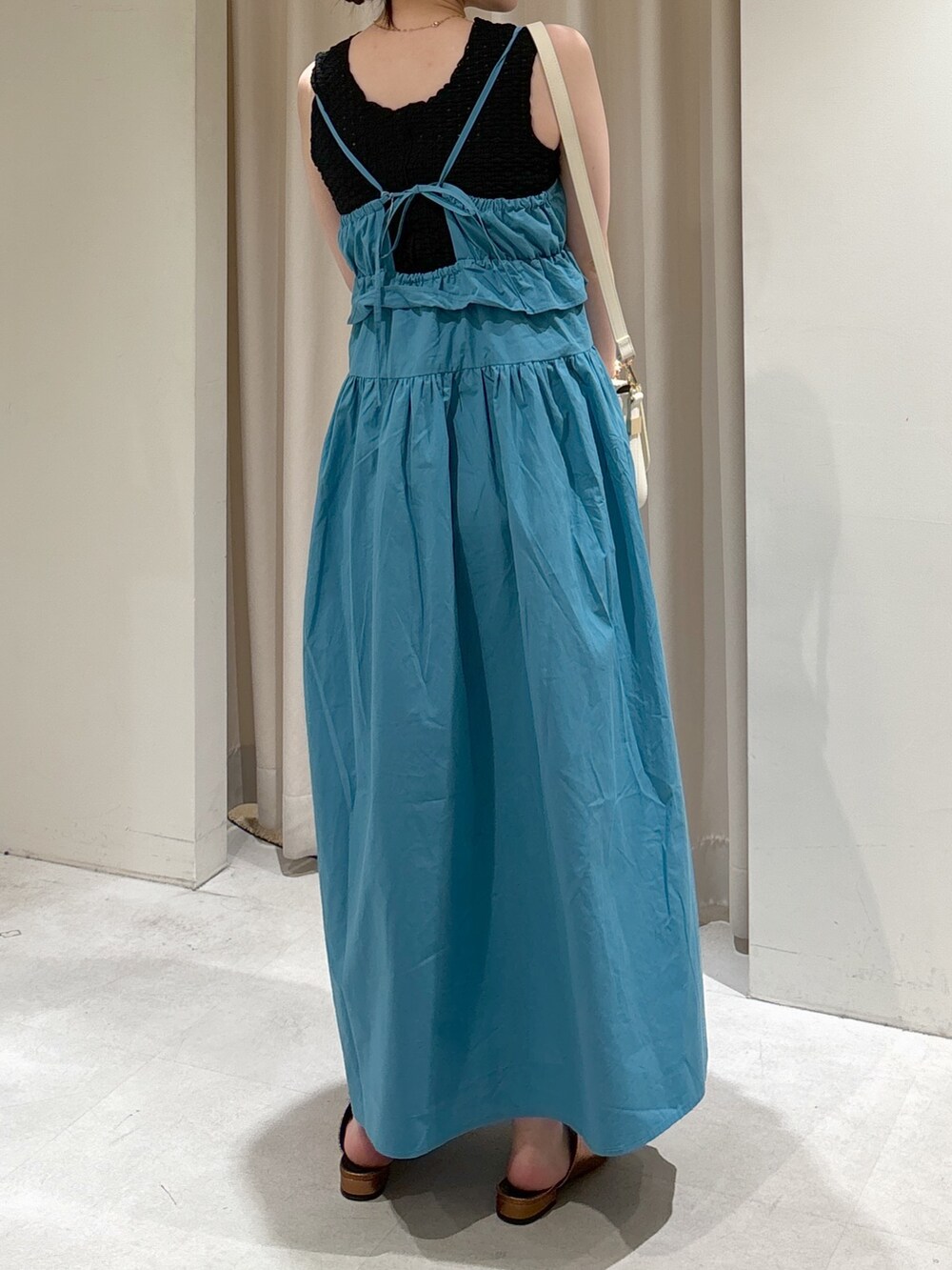 ブルー系のワンピース、ブラック系のタンクトップ、ホワイト系のショルダーバッグを着用したレディースの夏コーディネートの3枚目の写真