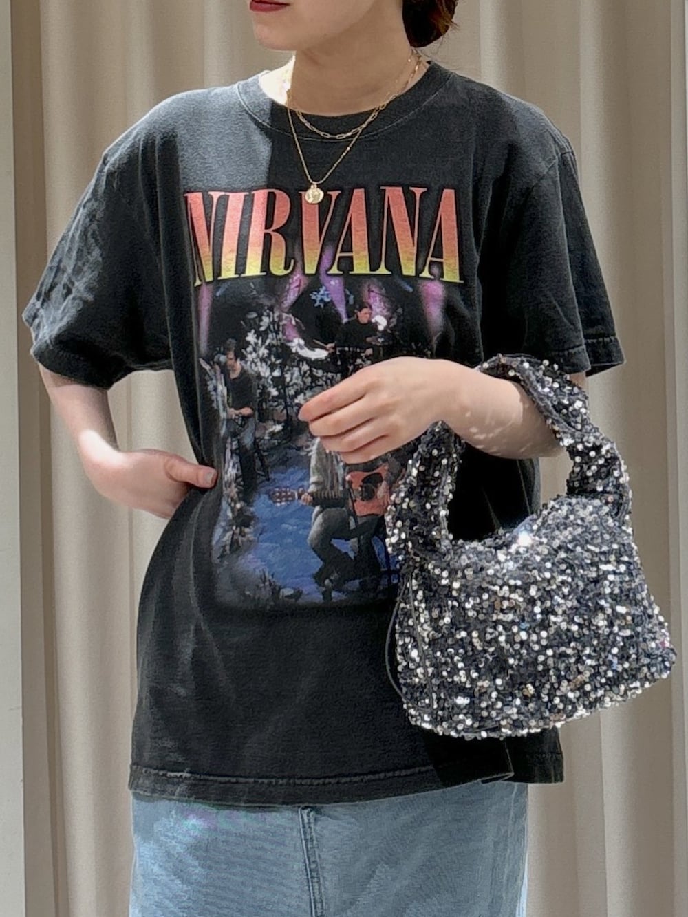 ブルー系のデニムスカート、ゴールド系のパンプス、ブラック系のTシャツ/カットソーを着用したレディースの春コーディネートの4枚目の写真