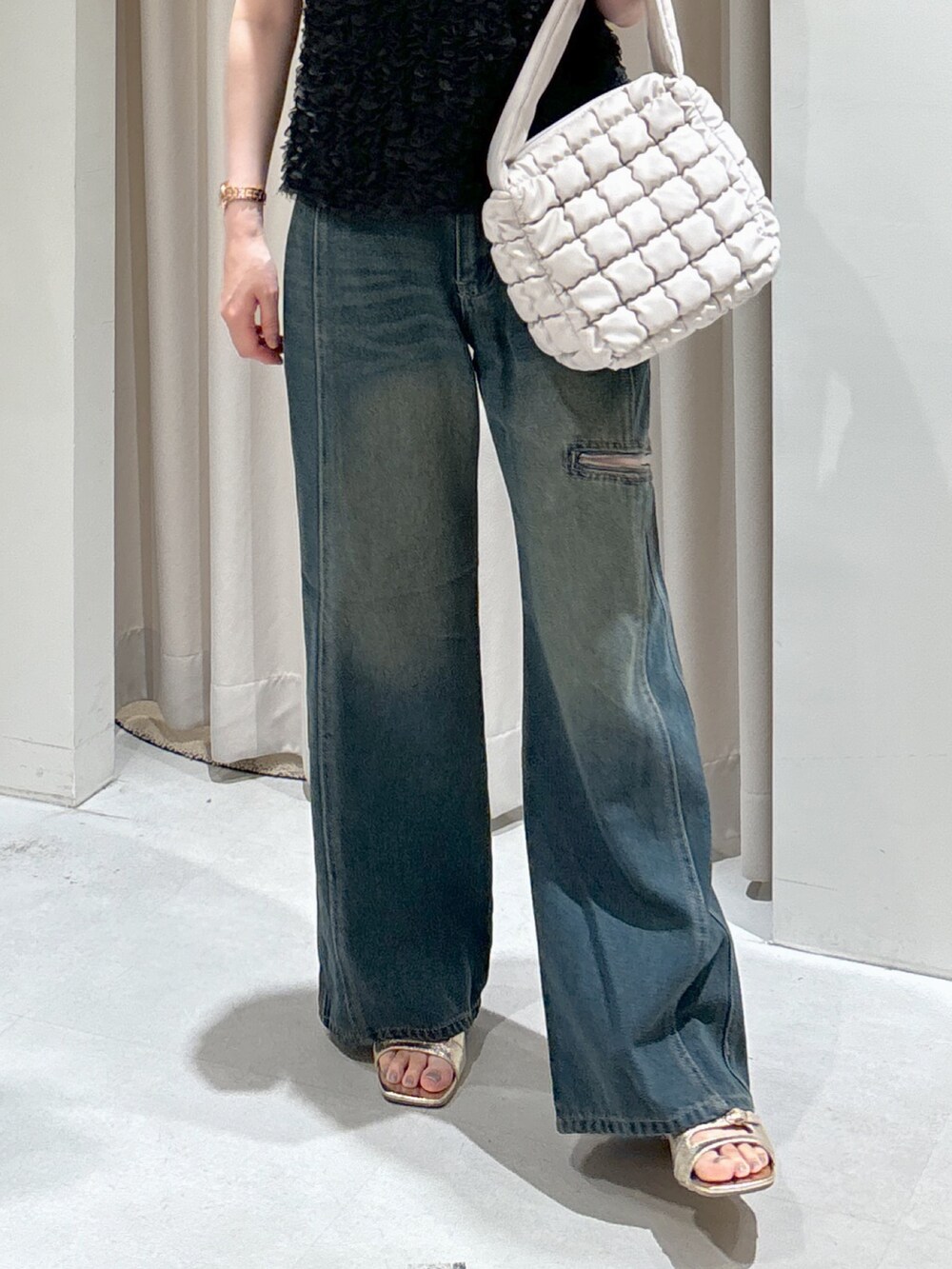 ブラック系のシャツ/ブラウス、ホワイト系のハンドバッグ、ブルー系のデニムパンツを着用したレディースの秋コーディネートの7枚目の写真